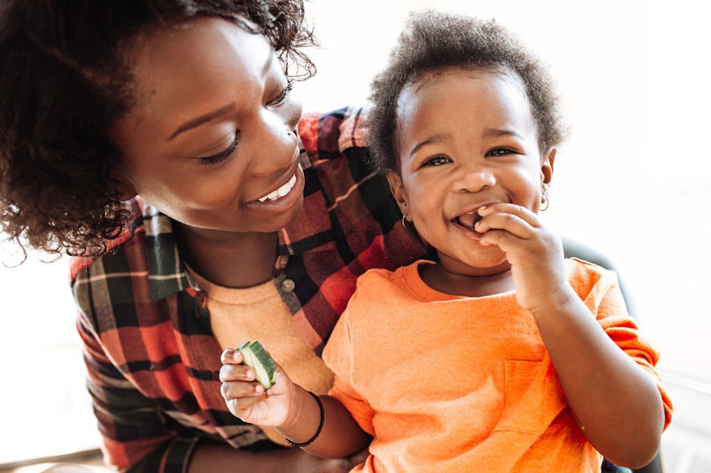Laughing toddler with mom